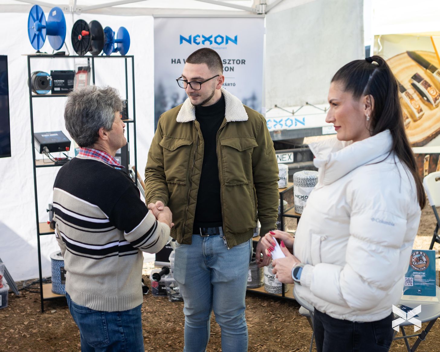 Nexon standnál történő kézfogás vásárló és képviselő között a vásáron