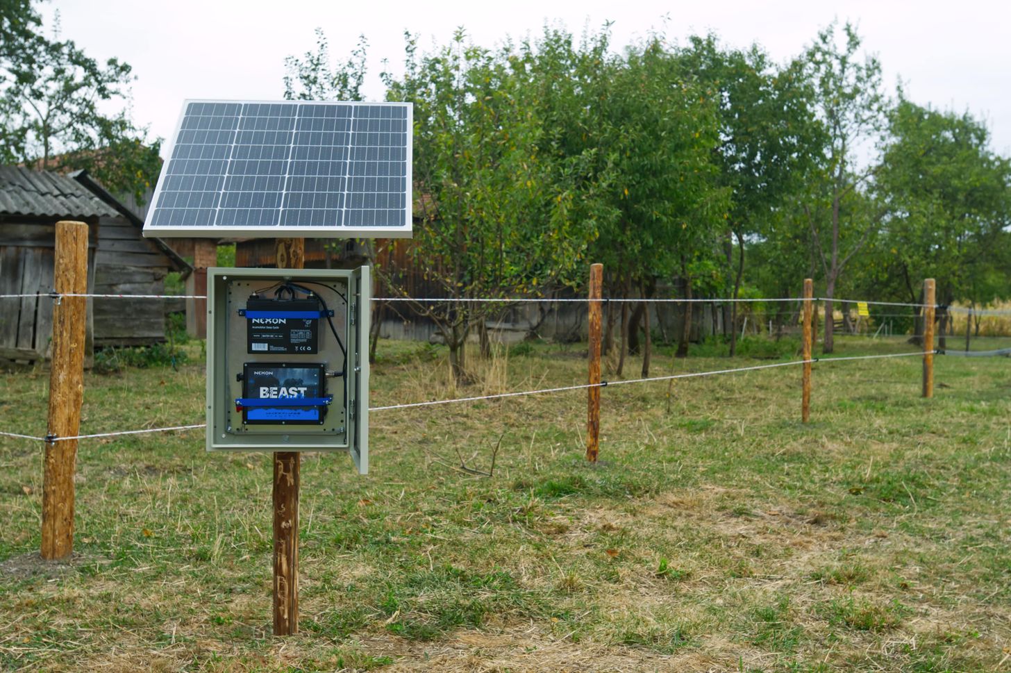 Solar-powered electric fence energizer installed on a farm for wildlife protection